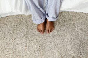 feet of african american woman sitting on bed