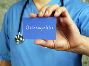 doctor holding sign that says Osteomyelitis